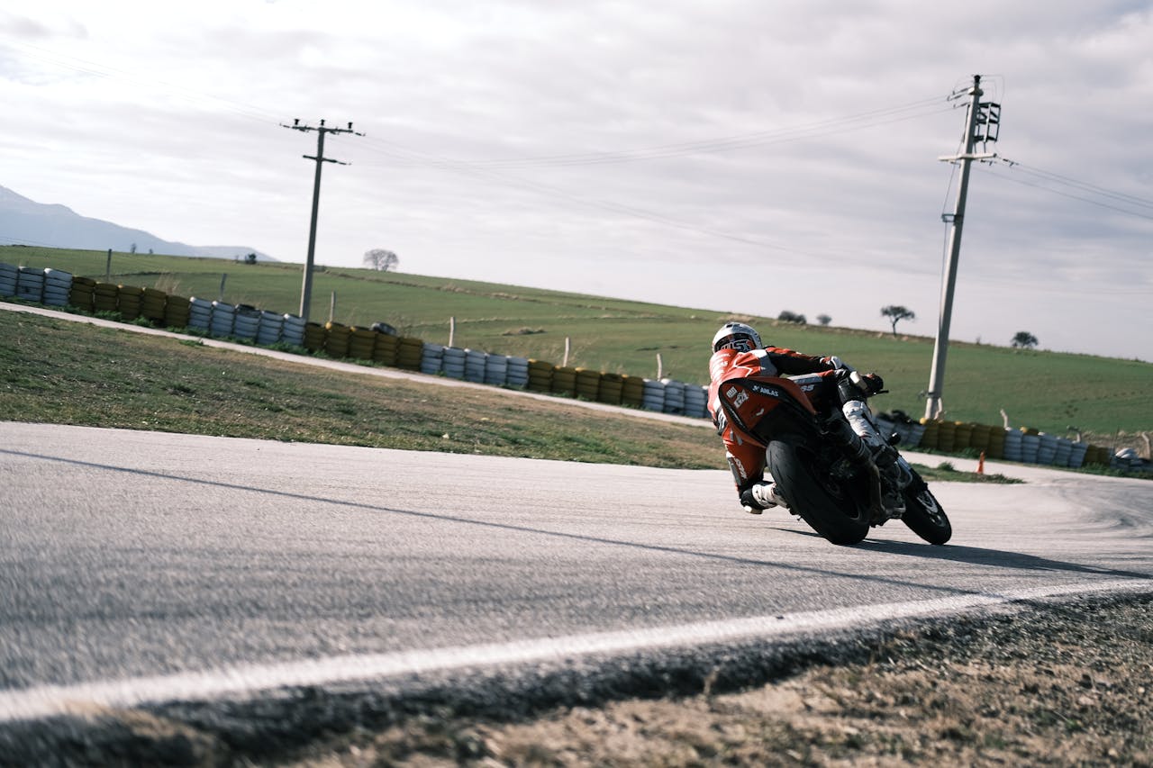 Motorcyclist riding on a winding track, showcasing speed and control in an outdoor setting.